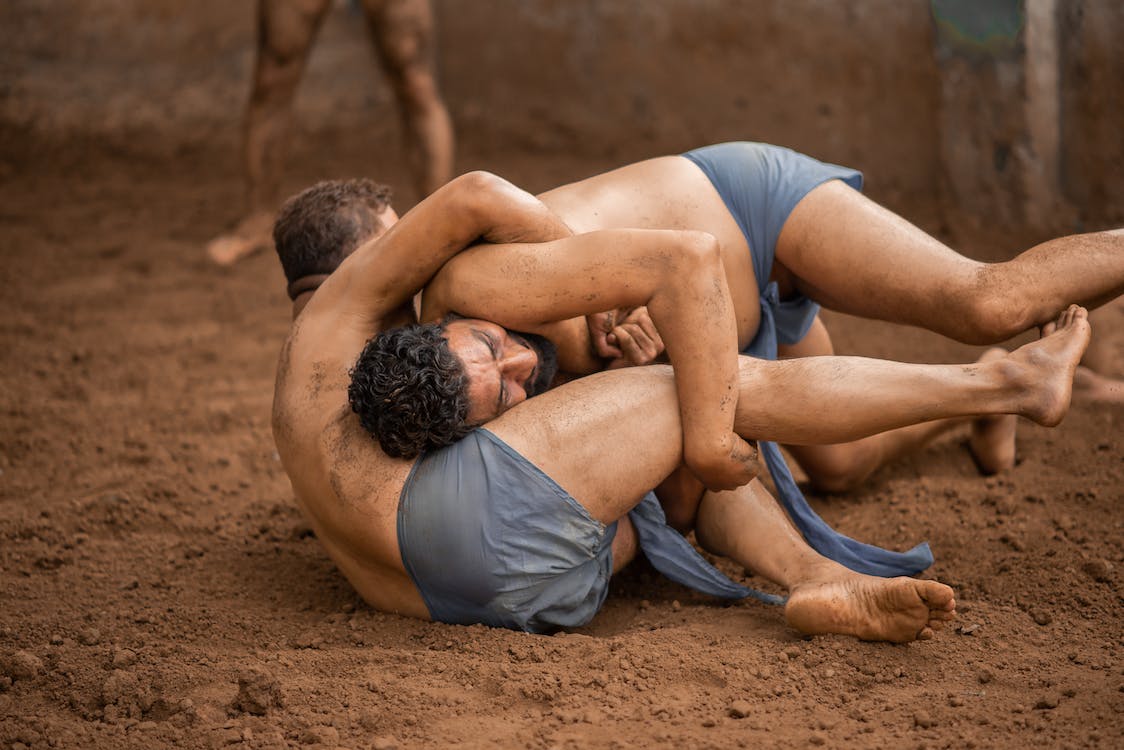 wo fighters wrestle in the sand
